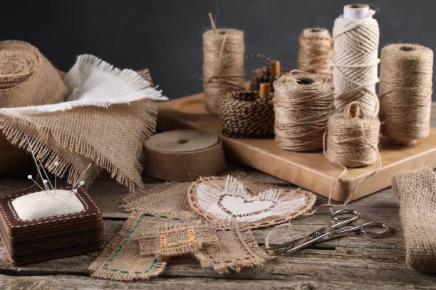 trozos de tela de arpillera, carretes de cordel y diferentes herramientas de costura sobre mesa de madera - textile burlap sewing patch fotografías e imágenes de stock