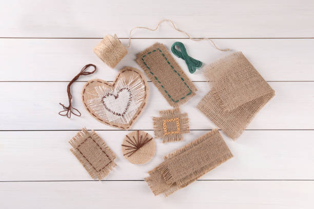 flat lay composition with pieces of burlap fabric on white wooden table - textile burlap sewing patch stock-fotos und bilder