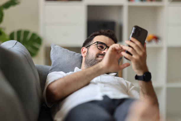 istock Young man text massaging on his smart phone at home. 1925433518