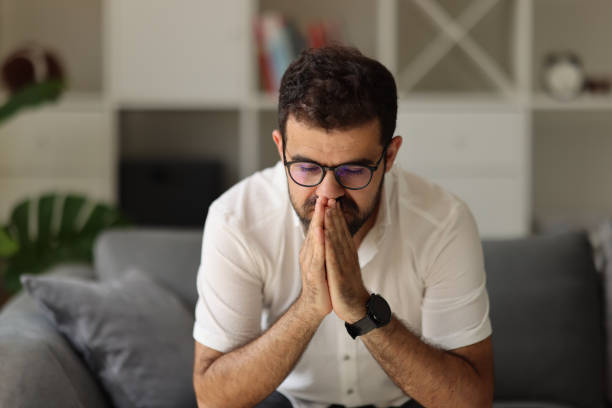 istock Man sitting alone at home looking sad and distraught 1925434044