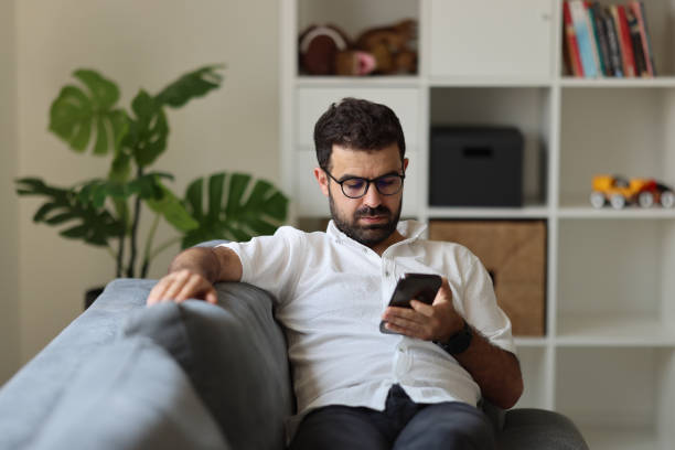 istock Young man text massaging on his smart phone at home. 1925434568
