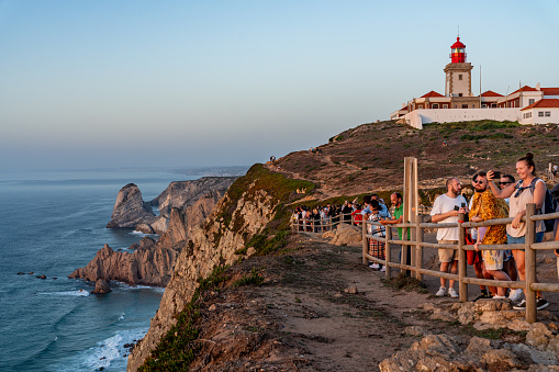 Tourists are enjoying sunset at Cabo da Roca, Westernmost Point of Continental Europe, Sintra, Portugal.
