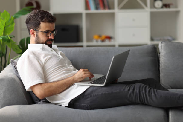 istock Young man using the laptop in the living room. 1925463768