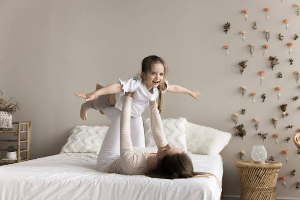 istock Sportive strong mom lifting kid in air, supporting child 1925464310