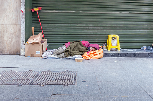 dramatic portrait of a little homeless boy, brick wall, poverty, city, street