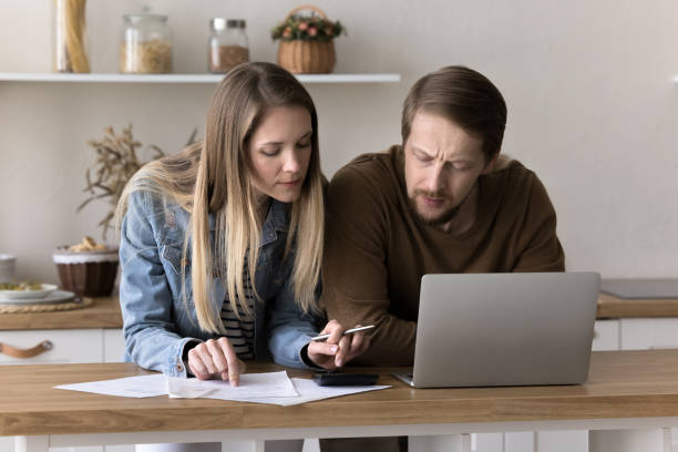 istock Focused married couple counting mortgage fees on calculator 1925483665