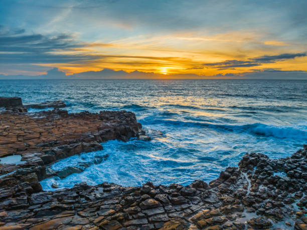istock Sunrise over the sea and rock platform with high cloud 1925487838