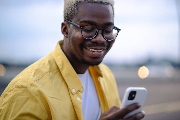 istock Cheerful African American young man using smart phone on the street 1925488349