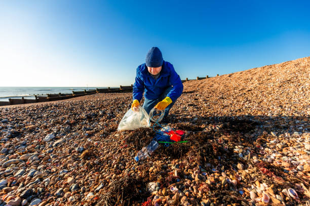 istock Mid adult man cleaning plastic pollution from the beach 1925500892