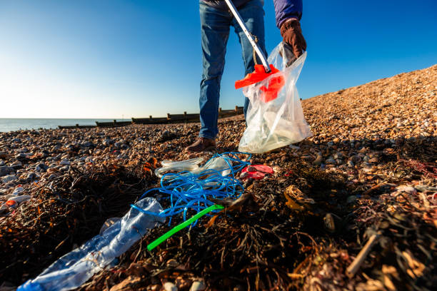istock Senior man cleaning plastic pollution from the beach 1925501919