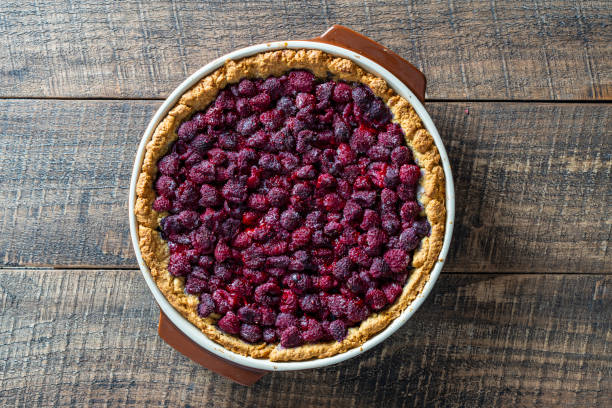 istock Raspberry pie in a ceramic dish on wooden background, closeup, top view 1925518863