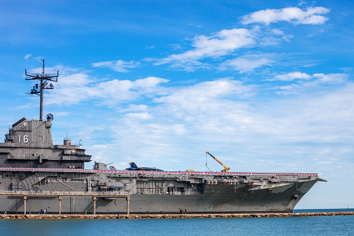 Norfolk, Virginia, USA - May 30, 2023: An American flag waves in the wind on the stern of the USS George H.W. Bush (CVN-77) aircraft supercarrier docked at Naval Station Norfolk while in port.