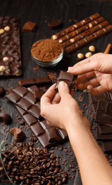 istock Chocolate, cocoa powder, coffee beans, girl's hands breaking chocolate. 1925581892