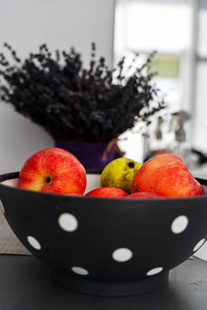 Red apples in a ceramic plate, on a background of lavender, composition
