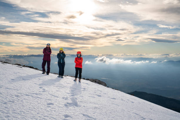 istock Female mountain climber team is looking at the camera while  standing on the summit of a high altitude mountain. 1925595575