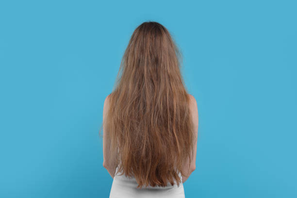 istock Woman with damaged hair on light blue background, back view 1925617558