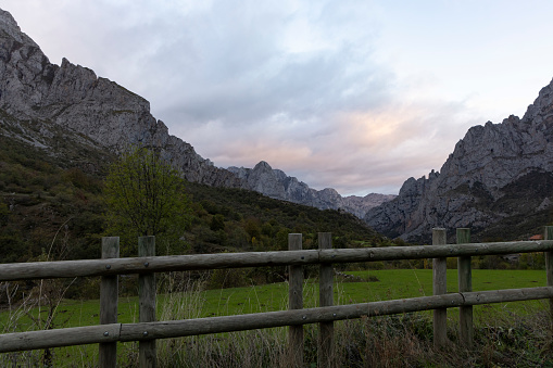 Sunrise landscape over Picos de Europa national park in northern Cantabrian mountains of Spain during bright and sunny autumn day with forest and mountain peaks