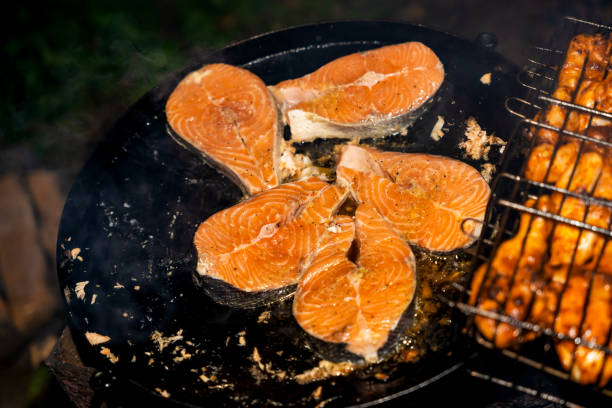 Appetizing pieces of red fish cooked on a charcoal grill roasting in smoke, nightly
