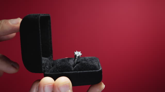 Will you marry me? Male hands holding black velvet box with engagement ring