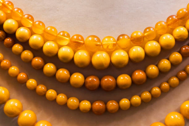 Amber texture selective focus background, stones yellow orange color. Natural gemstone mineral for jewelry.  Amber textured fon with bokeh. Sunstones pieces ancient resin. Transparent pieces gem.
