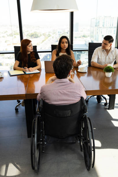 istock Rear view of a disable man in a wheelchair getting interviewed for a job 1925646069