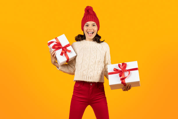 istock Excited lady posing with holiday wrapped presents over yellow backdrop 1925646101
