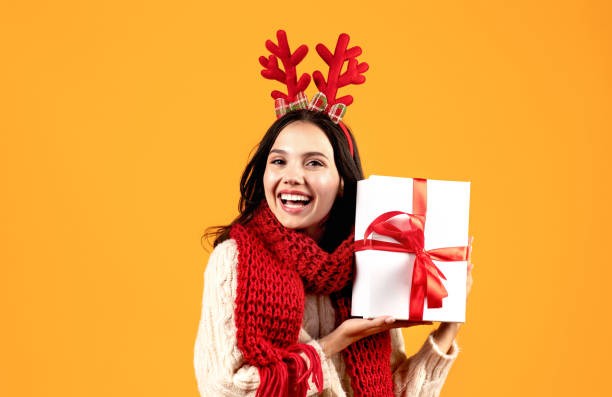 istock Joyful Young Woman Holding Present Box On Yellow Studio Background 1925646623