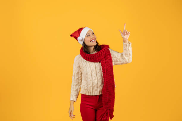istock Happy lady in red knitwear pointing up on yellow backdrop 1925646673