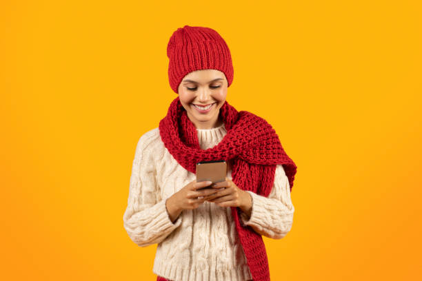 istock Smiling Lady Messaging On Cellphone Wearing Knitwear On Yellow Background 1925647232