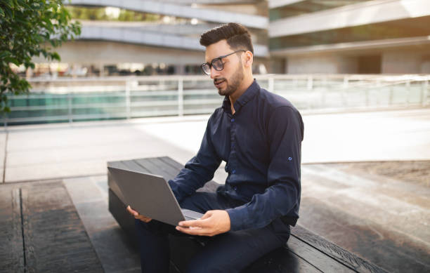 istock Young arabic businessman browsing on his laptop checking emails outdoor 1925672027