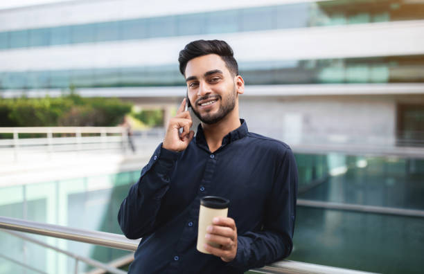 istock Middle Eastern business man talking on cellphone near office center 1925672044