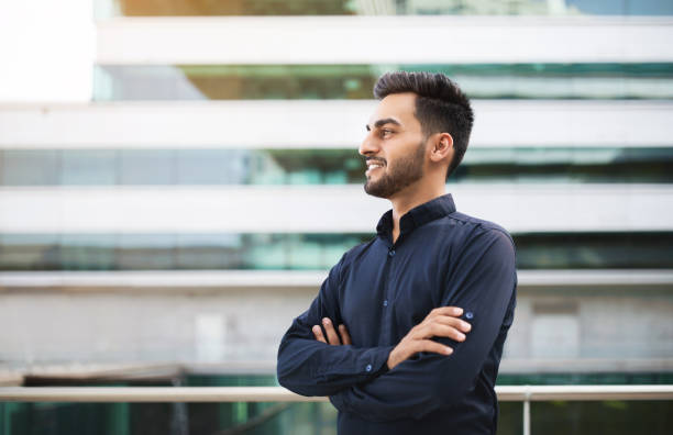 istock Confident arabic young guy posing against modern business building 1925672052