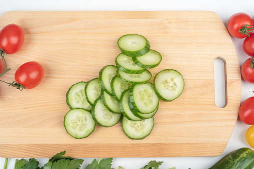Sliced cucumber pieces on a cutting board. Preparing the salad. Home cooking.