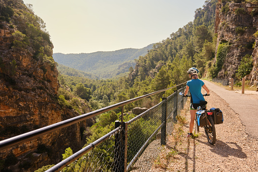 Woman cyclist admiring the scenery while riding along a greenway in Spain