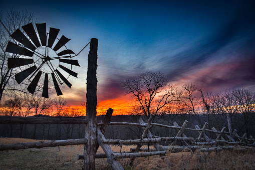 windmill and wooden fence line in rural Arkansas setting