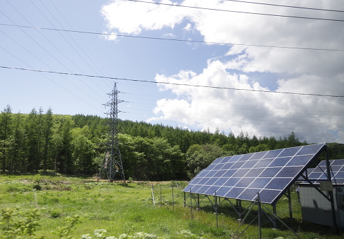 Teshikaga, Japan - June 5, 2023: An electrical grid extends over the green hills of Teshikaga. Spring afternoon in Kushiro Subprefecture, Hokkaido Prefecture.