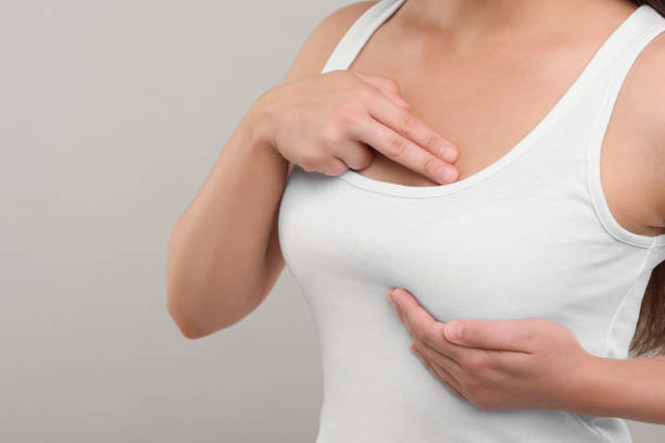 istock Woman doing breast self-examination on light grey background, closeup 1925719546