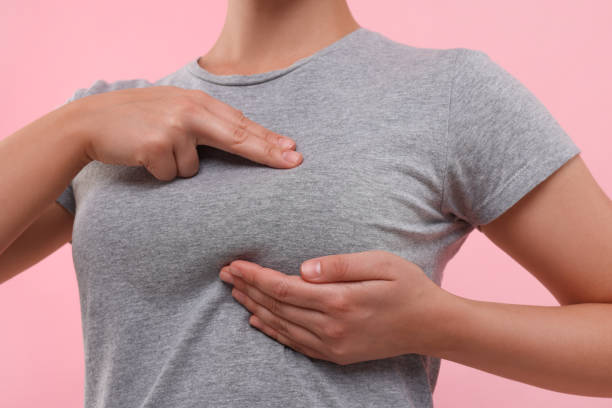 istock Woman doing breast self-examination on pink background, closeup 1925720073