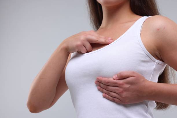 istock Woman doing breast self-examination on light grey background, closeup 1925720612