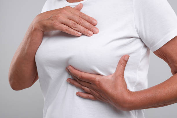 istock Woman doing breast self-examination on light grey background, closeup 1925723235