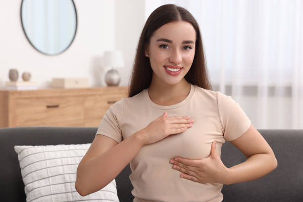 istock Beautiful young woman doing breast self-examination at home 1925747310
