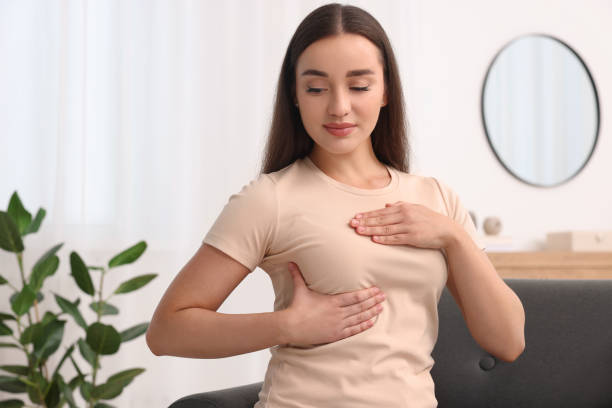 istock Beautiful young woman doing breast self-examination at home 1925747880