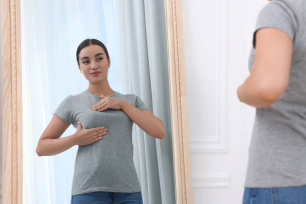 istock Beautiful young woman doing breast self-examination near mirror indoors 1925751016