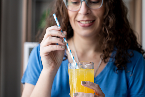 Woman drinking iced juice through a straw