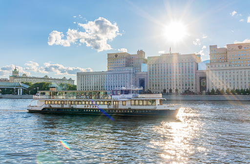 Moscow, Russia - July 30, 2022: View of the Ministry of Defence of Russian Federation, and Moscow river embakment with cruise ships at sunset. Translation of the inscription on the facade - Ministry of Defense of the Russian Federation