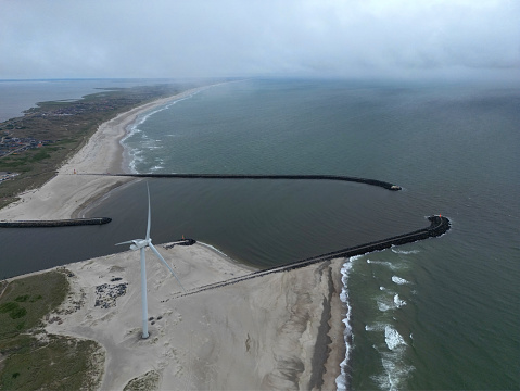 Power generating windturbines at the beach on a cloudy afternoon in the small fishing village of Hvide Sande in the western part of Denmark