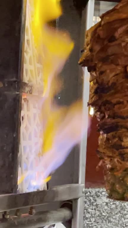 Tacos Al Pastor Pork and Beef Meat Being Sliced from a Rotisserie Spit in an Open Air Restaurant in Downtown Mazatlan Mexico