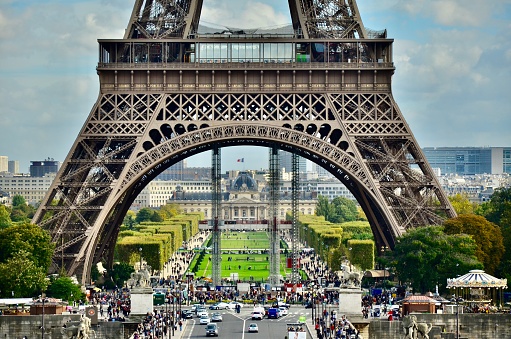 A landscape shot of the Eiffel Tower from a distance, capturing its full, towering stature against the Parisian skyline, with a clear view of its intricate metal structure.