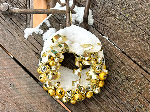 Christmas wreath on white wall. Cones, glass balls, dried mugs of oranges, Christmas stars, cotton bolls and fir tree branches.