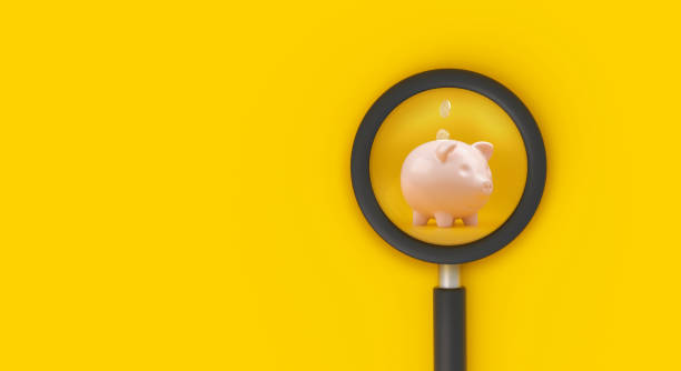 istock Piggy bank through magnifying glass on yellow background. 3D rendering. 1925937820